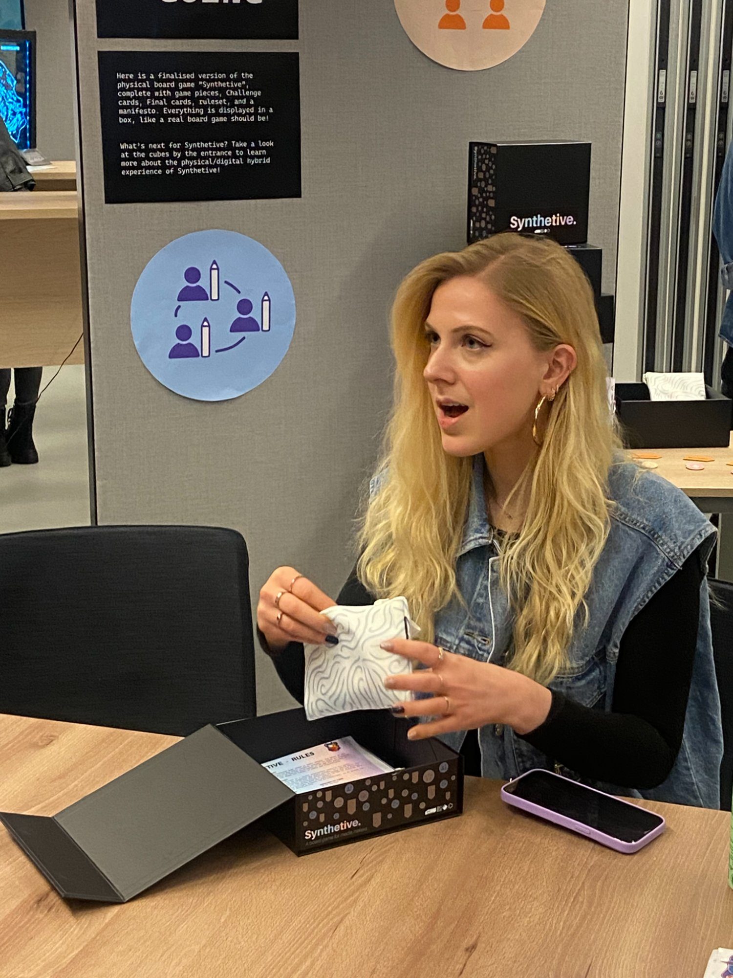 Woman opening Synthetive game box at launch event